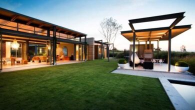 Elegancki nowoczesny dom z dużymi przeszkleniami i przestronnym ogrodem, idealny do relaksu i wypoczynku na świeżym powietrzu.