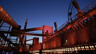 Kopalnia przemysłowa oświetlona nocą, industrialny widok z dużymi strukturami i światłami, idealna ilustracja przemysłu, technologii i energii dla stron internetowych i materiałów promocyjnych.