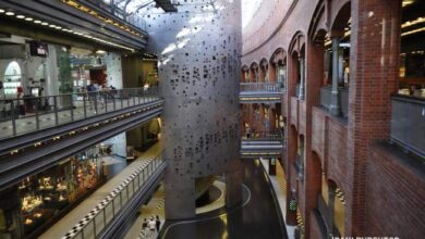 Nowoczesna wielopoziomowa przestrzeń handlowa z unikatową architekturą, łącząca tradycyjne ceglane ściany z nowoczesnym designem, idealna dla sklepów i biur.