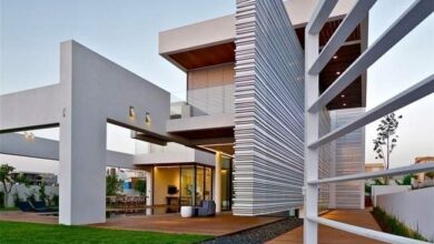 Nowoczesny budynek mieszkalny z unikalną architekturą, duże okna i przestronne tarasy, elegancki design, idealny do zamieszkania w komfortowej i nowoczesnej przestrzeni.