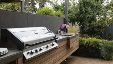 Grill gazowy na zewnątrz w nowoczesnej przestrzeni ogrodowej, idealny do grillowania i relaksu na świeżym powietrzu z aromatyczną dekoracją kwiatową.