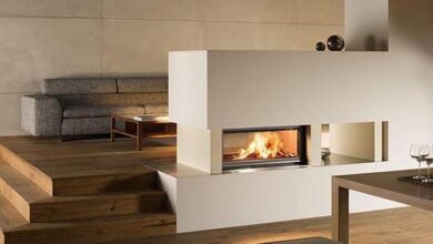Nowe nowoczesne wnętrze z kominkiem, przestronny salon z wygodną sofą i drewno na podłodze, idealne do relaksu i spotkań rodzinnym, elegancki design i przytulna atmosfera.