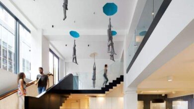 Nowoczesne biuro z mezzanine z dużymi oknami i unikalnymi dekoracjami na suficie, idealne dla optymalnych rozwiązań biurowych.