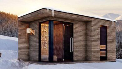 Urocza nowoczesna sauna w otoczeniu zimowego krajobrazu, wykonana z drewna, idealna na relaks po nartach, z trwałą konstrukcją i chłonnością ciepła.