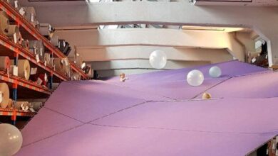 Hala magazynowa z dużą atrakcją, kolorowa poduszka powietrzna i balony, idealna na eventy i imprezy integracyjne, kreatywne rozwiązania dla rozrywki w dużej przestrzeni biurowej i konferencyjnej.