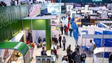 Przemysłowa hala targowa z stoiskami wystawców i zwiedzającymi podczas wydarzenia branżowego. Nowoczesne ekspozycje i prezentacje produktów w dynamicznej atmosferze konferencji i targów.