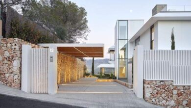 Nowo wybudowana nowoczesna willa z elegancką bramą i parkingiem, otoczona oryginalnym murem z kamienia i minimalistycznym ogrodzeniem, w harmonii z naturalnym otoczeniem, idealna dla osób ceniących luksus i styl.