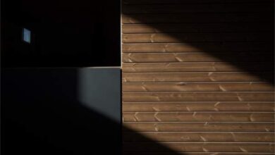 Mocne światło i cień na nowoczesnej drewnianej elewacji domu, architektura, elewacja z drewna, design nowoczesny, luksusowe wykończenie z naturalnego drewna.