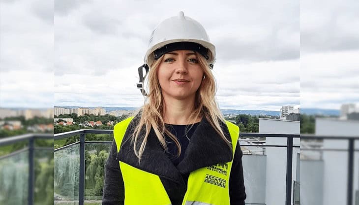 Panidyrektor, kobieta inżynier w kasku i kamizelce odblaskowej na dachu budynku, architektura, bezpieczeństwo pracy, wizja rozwoju, nowoczesne budownictwo, profesjonalistka w branży budowlanej.