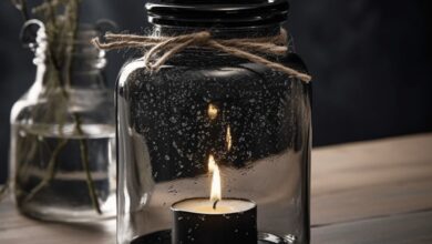 Lampka w słoiku z czarną świecą i płonącym knotem, dekoracja, nastrojowe oświetlenie, styl rustykalny, eleganckie akcesoria do wnętrz, atmosfera relaksu i ciepła, idealny dodatek do aranżacji wnętrza, romantyczne oświetlenie, dekoracja z naturalnych materiałów.